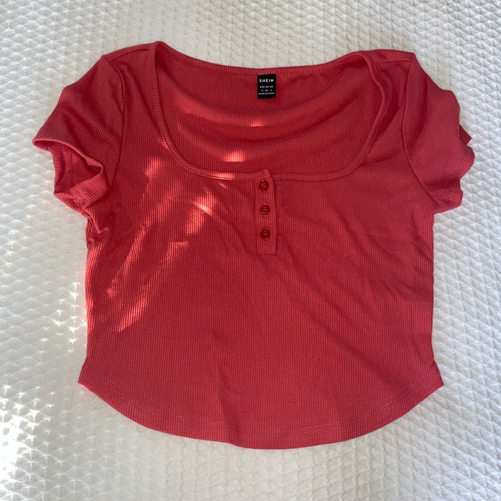 A light red cropped shirts with buttons in the front